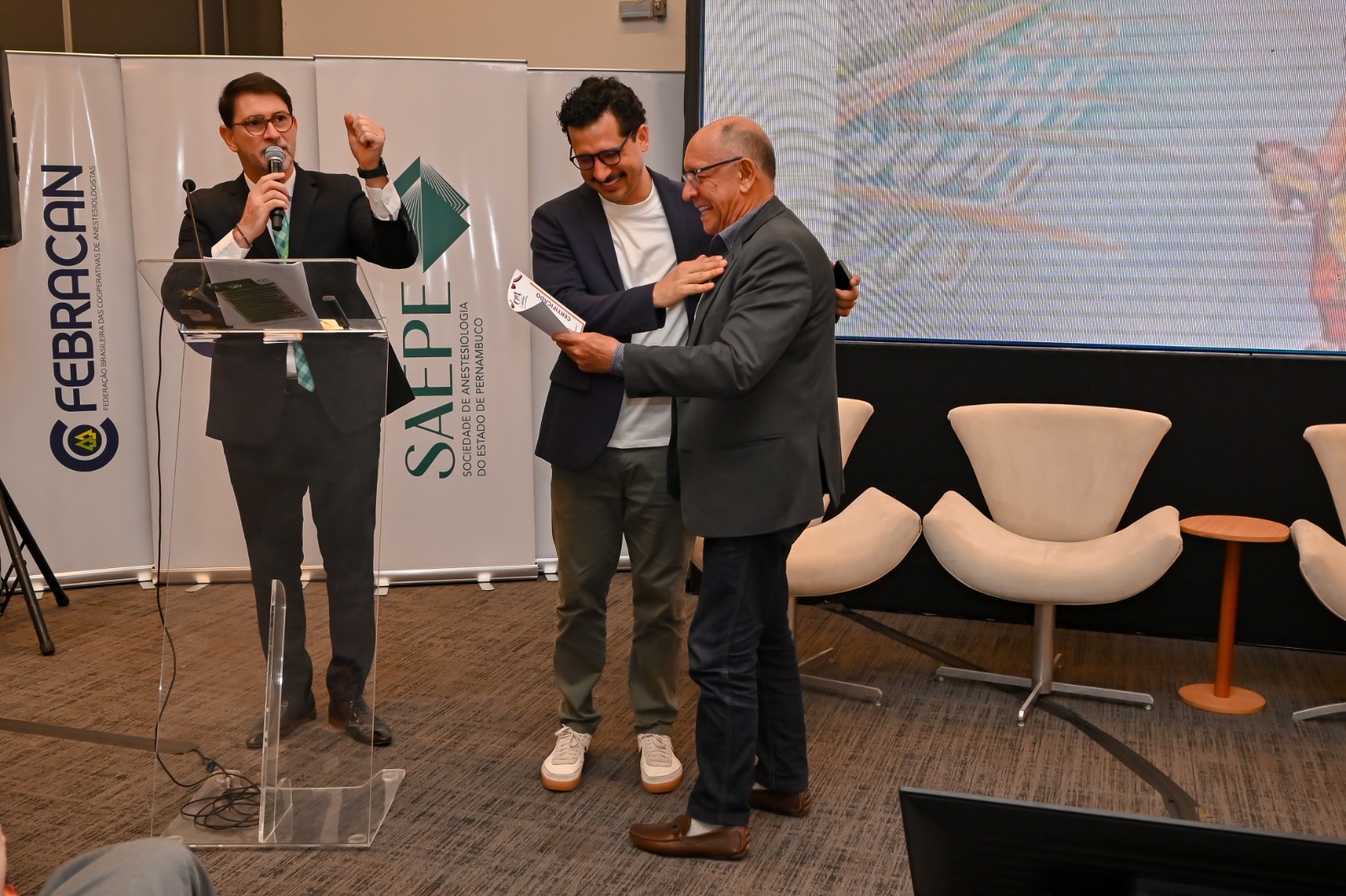 Cleber Zequetto participa de uma entrega de certificado no palco