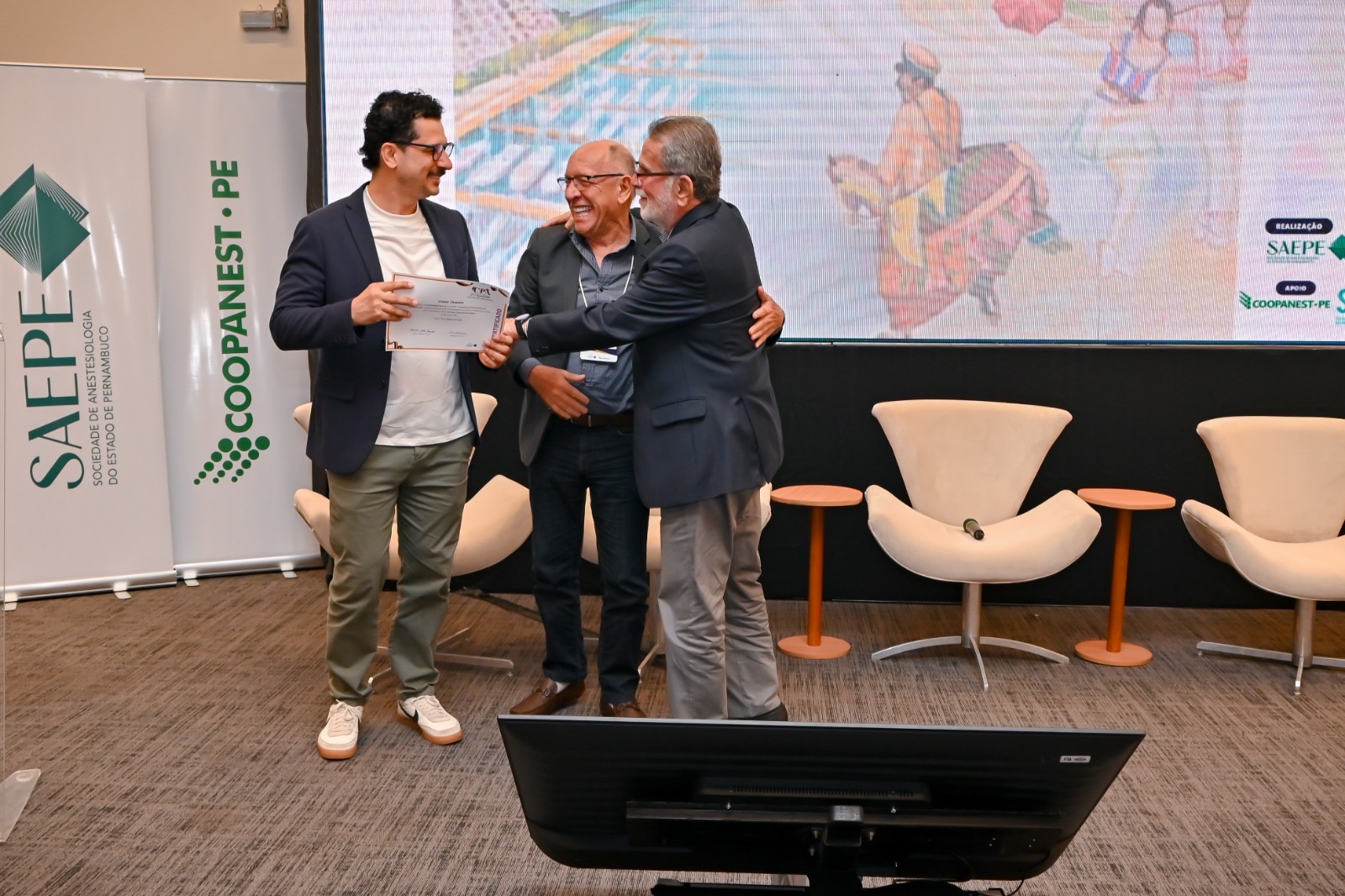 Participantes celebram uma entrega de reconhecimento no palco