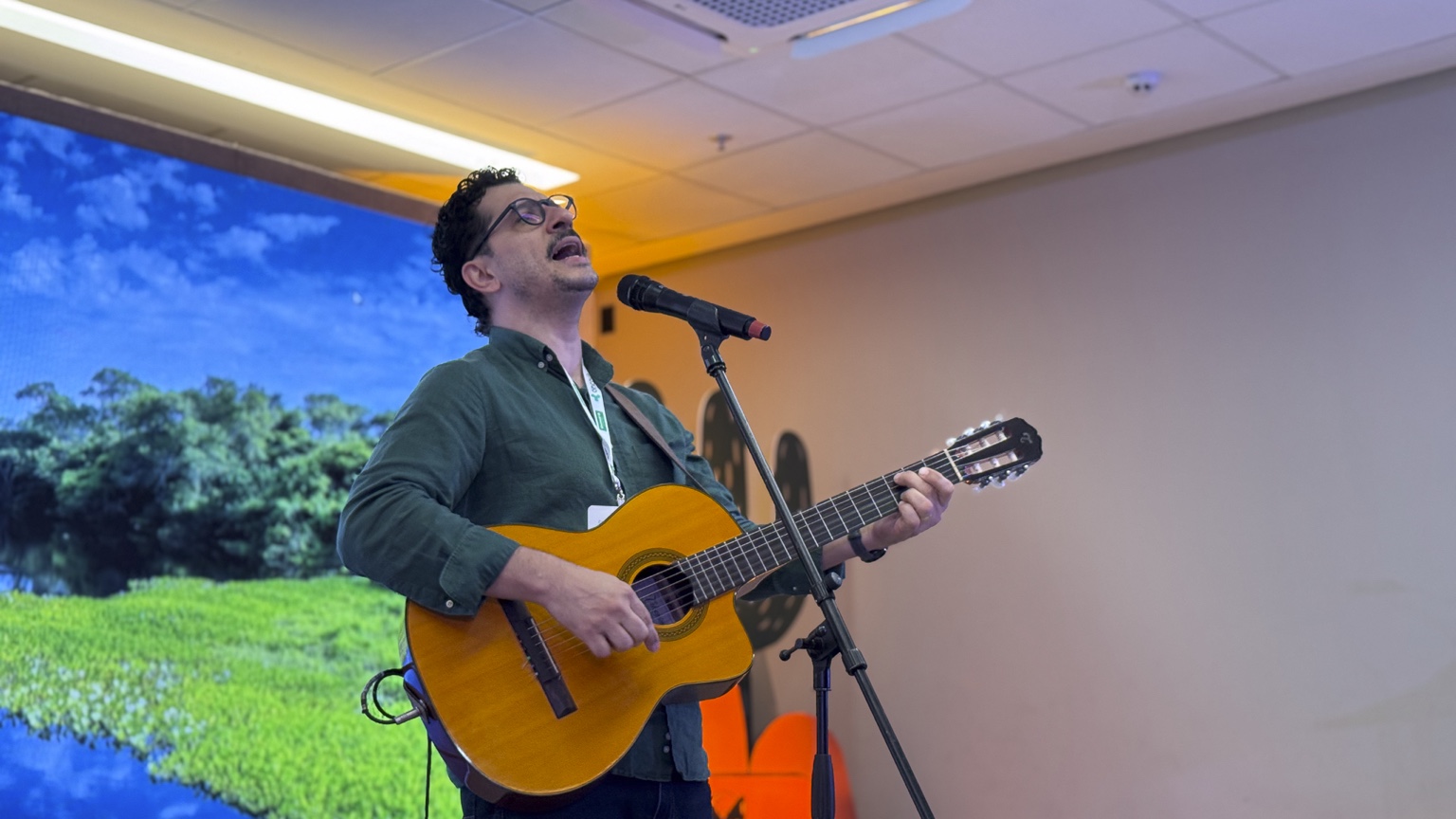 Cleber Zequetto canta e toca violão durante sua participação no Simpósio das Unimeds